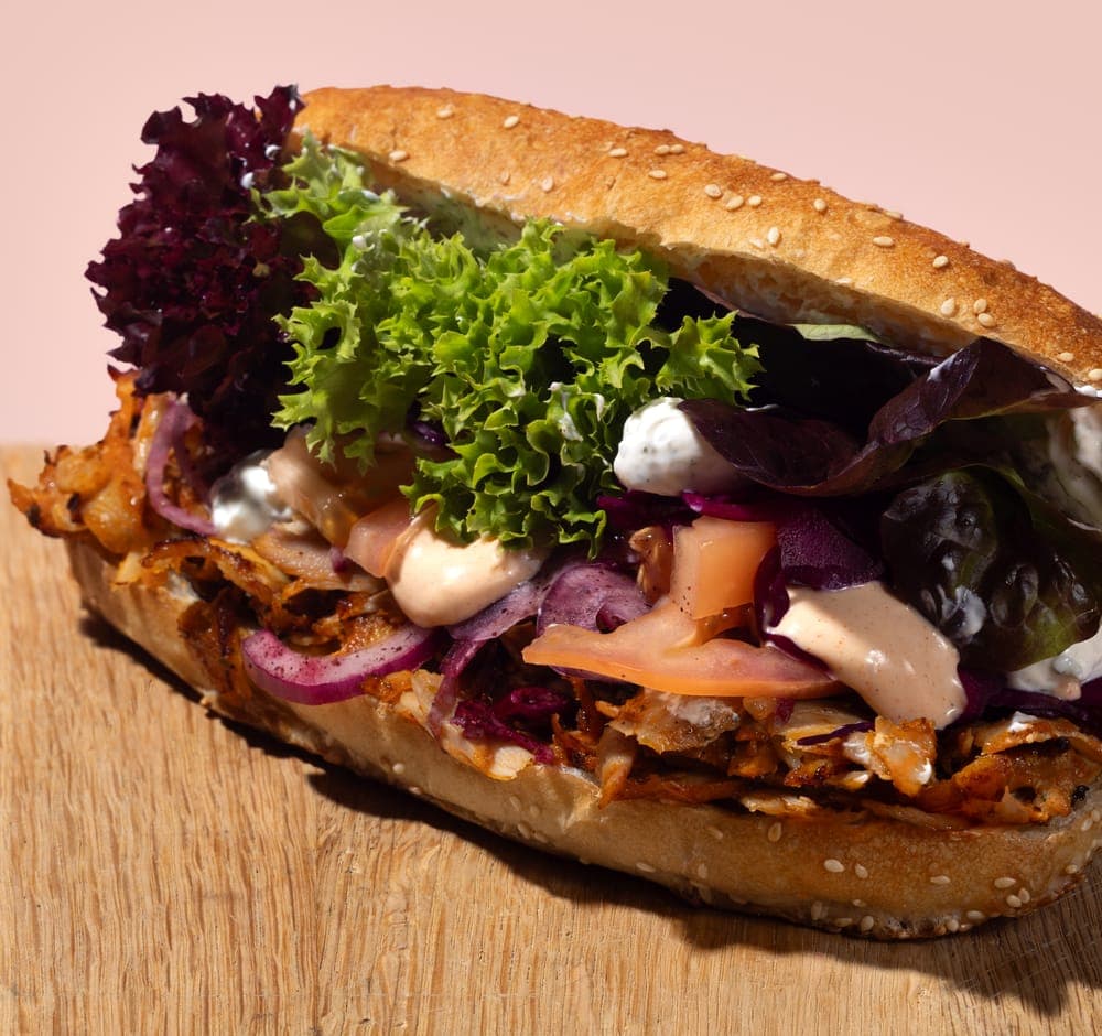 Döner Sandwich mit frischen Zutaten auf Holztisch